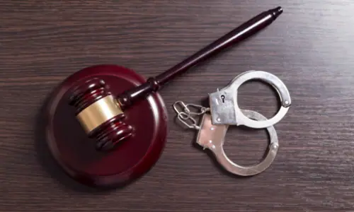 Gavel and handcuffs on a wooden desk