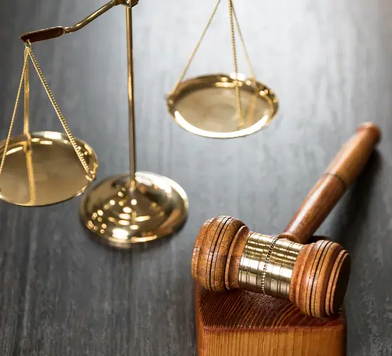 Brass scales of justice beside a wooden gavel