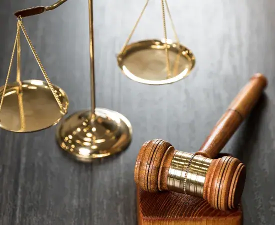 Brass scales of justice beside a wooden gavel