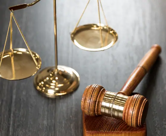 Brass scales of justice beside a wooden gavel