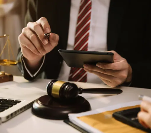 Lawyer reviewing case papers on a tablet beside a gavel