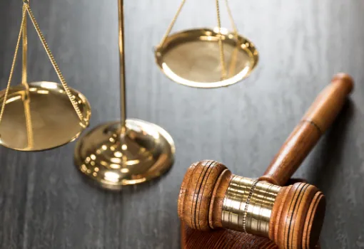 Brass scales of justice beside a wooden gavel