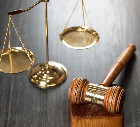 Brass scales of justice beside a wooden gavel