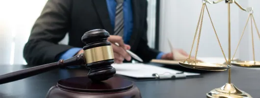 Lawyer at a desk with a gavel and brass scales of justice