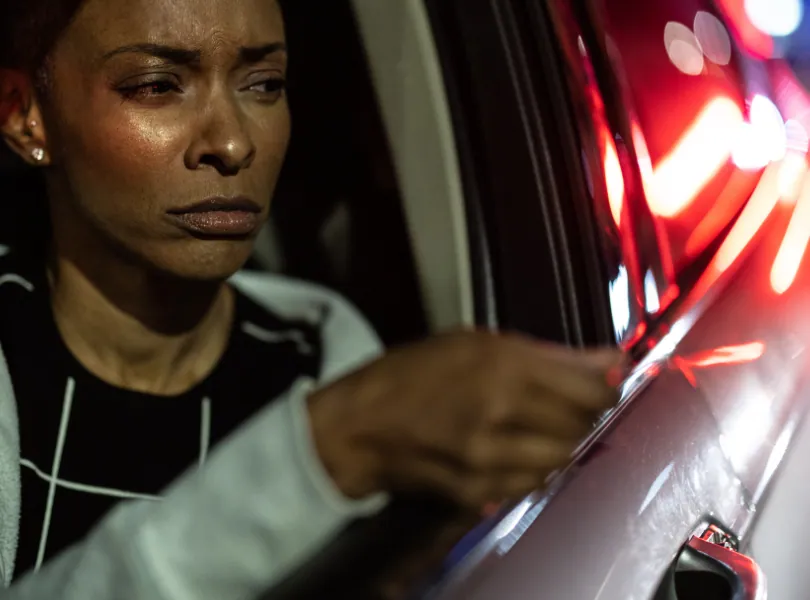 Driver stopped at night with police lights behind her car