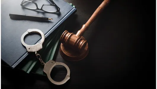 Handcuffs and a gavel resting on law books