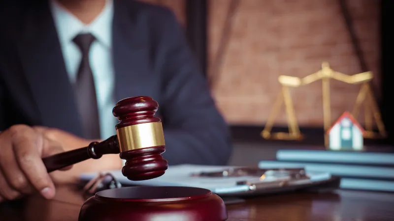 Judge holding a gavel in front of scales of justice